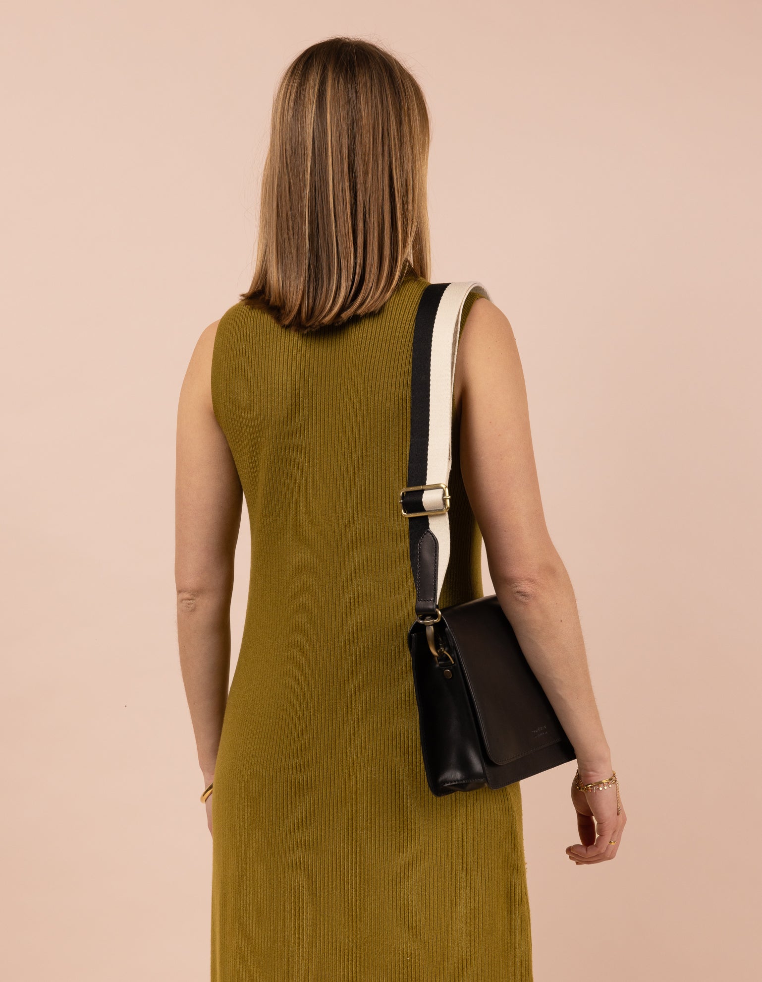 Model image with a black leather bag and an black and white cotton strap