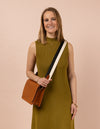 Model image with a brown leather bag and an black and white cotton strap