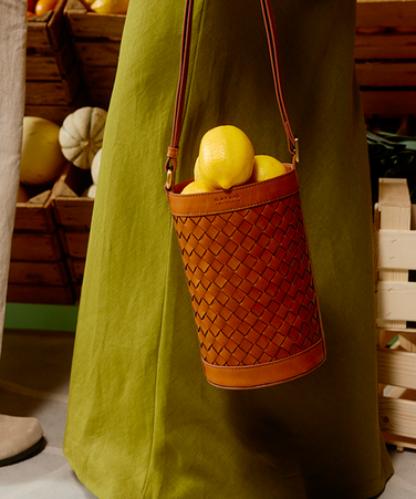 Woven bucket bag in brown leather with lemons inside