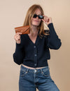 Sunglasses case in cognac classic leather. Female model product image.