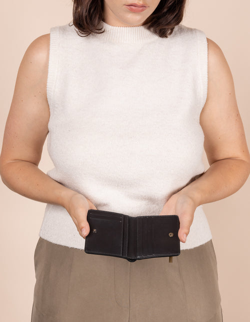 Alex fold over wallet in black apple leather - model holding it open