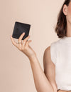 Alex fold over wallet in black apple leather - model holding it