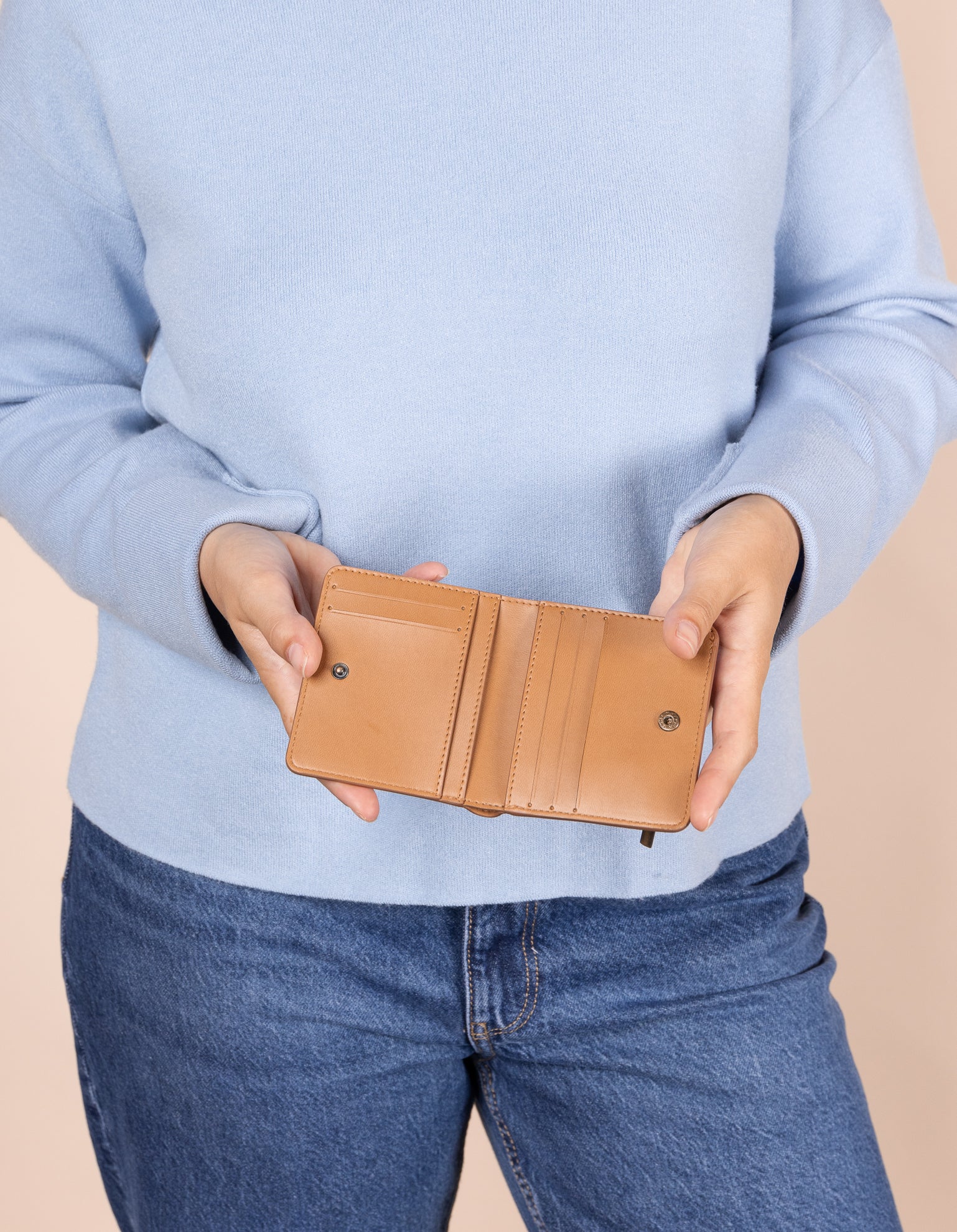 Alex fold over wallet in cognac apple leather - model holding it open
