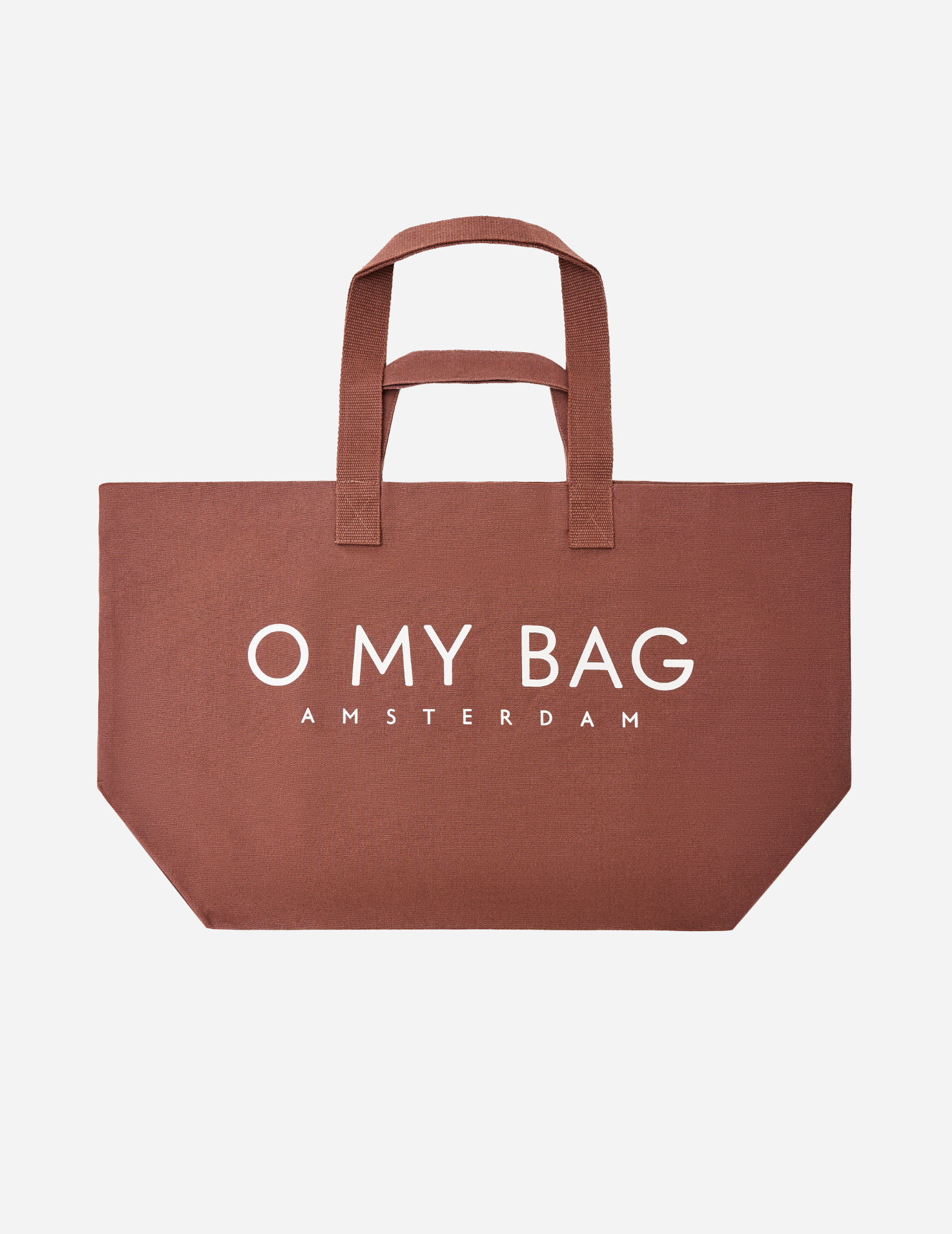 A Cocoa brown canvas tote bag with white printed text reading 'O MY BAG AMSTERDAM' on the front, set against a plain light gray background.