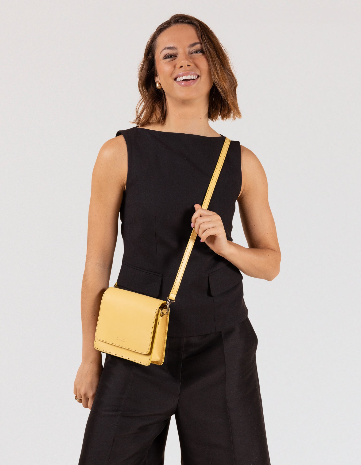 Model wearing Audrey Mini bag in Butter Yellow