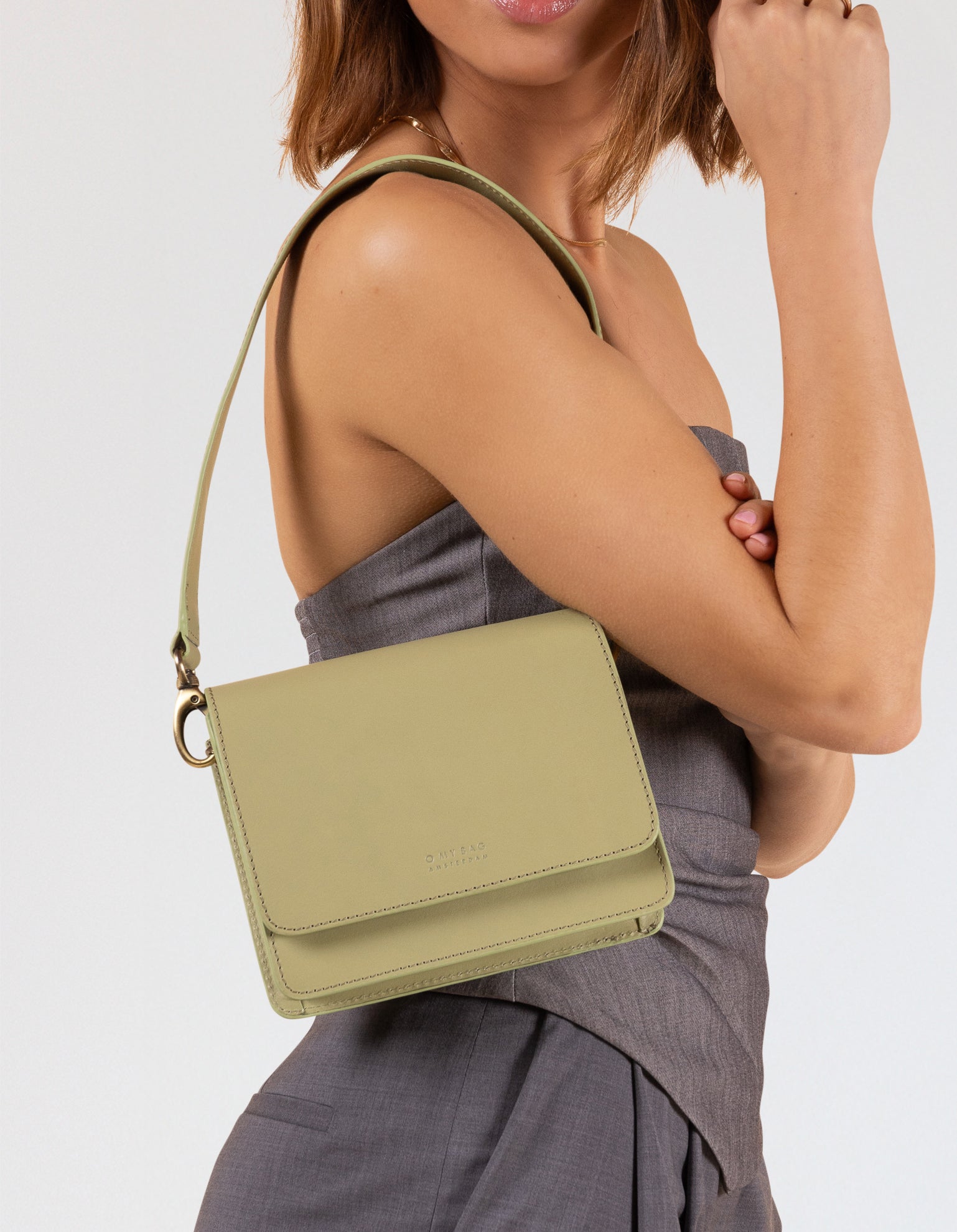 Model wearing Audrey Mini bag in Tea Green