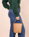 Female model wearing vegan apple leather Bobbi bucket bag by her side