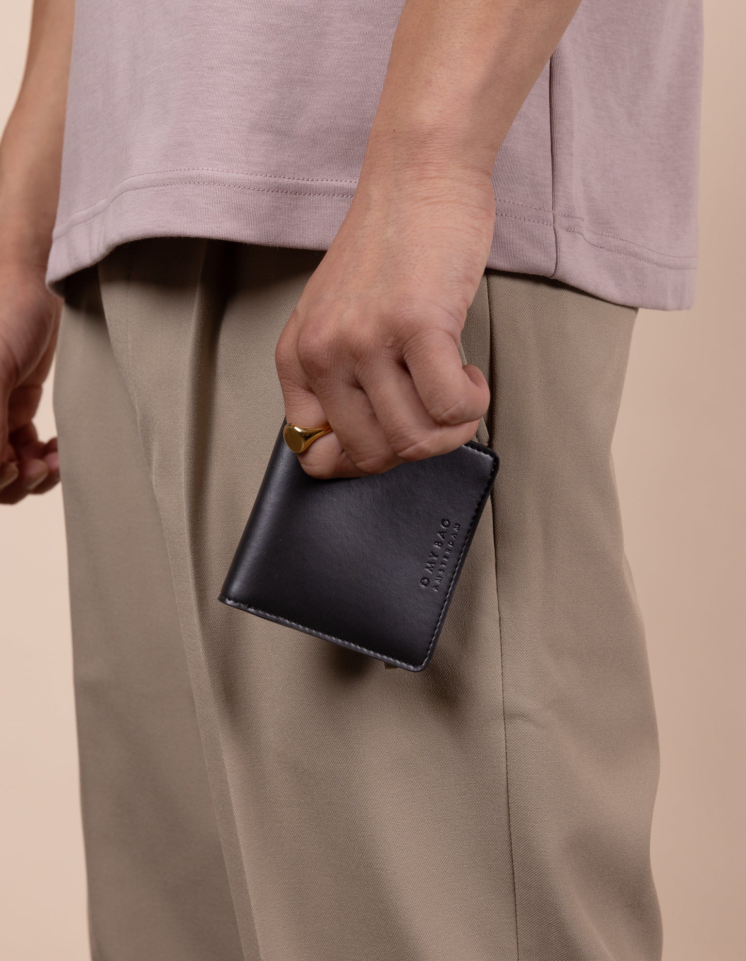 Alex fold over wallet in black apple leather - model holding it