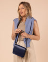 Model image showcasing Audrey Mini midnight blue classic leather crossbody bag with shoulder leather strap