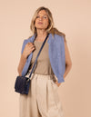 Model image showcasing Audrey Mini midnight blue classic leather crossbody bag with adjustable leather strap