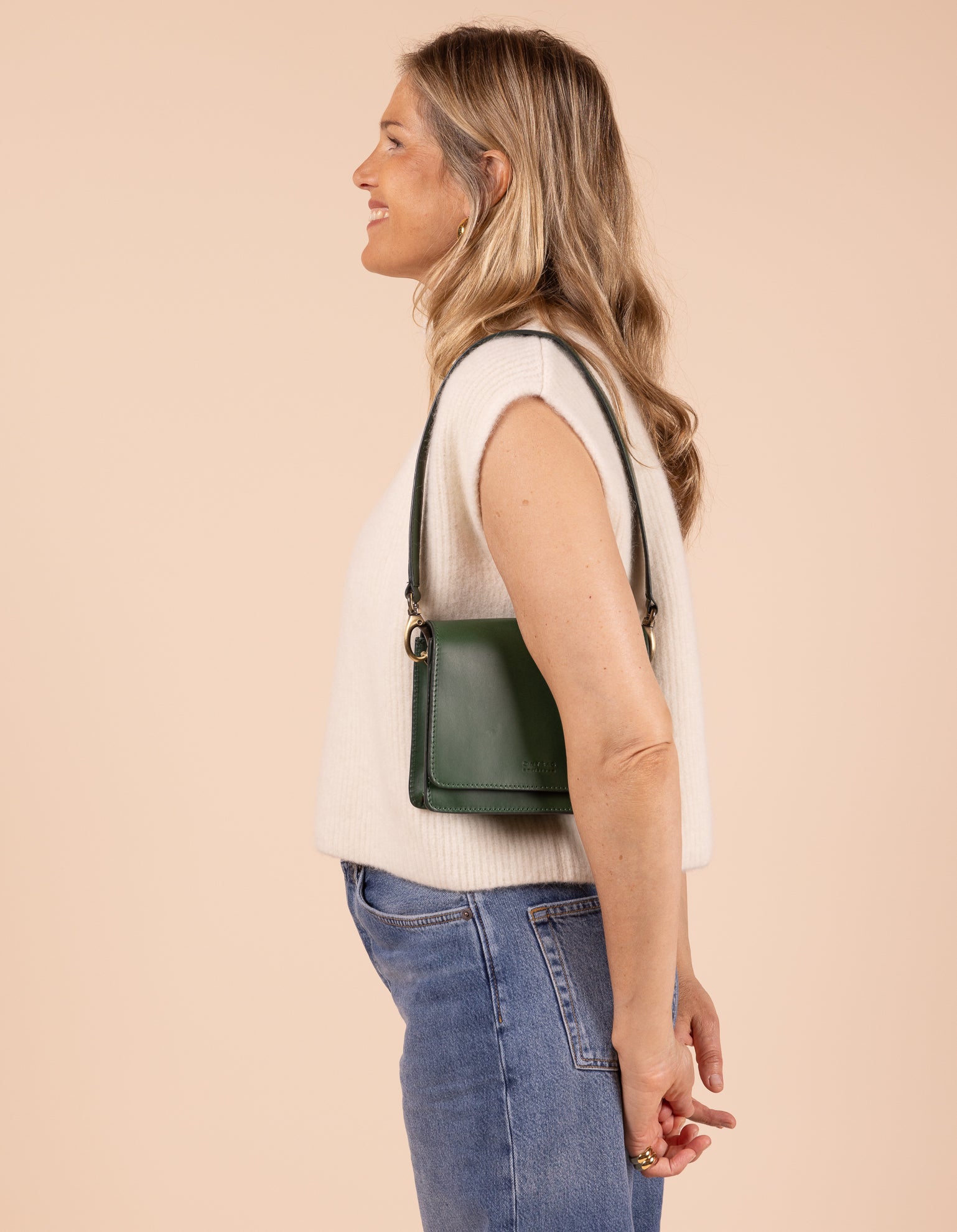 Model image showcasing Audrey Mini pine green classic leather crossbody bag with shoulder leather strap