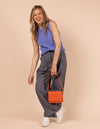 Model image showcasing Audrey Mini tangerine classic leather crossbody bag with shoulder leather strap