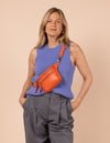 Model image showcasing Beck's Bum Bag tangerine classic leather fanny pack with adjustable leather strap