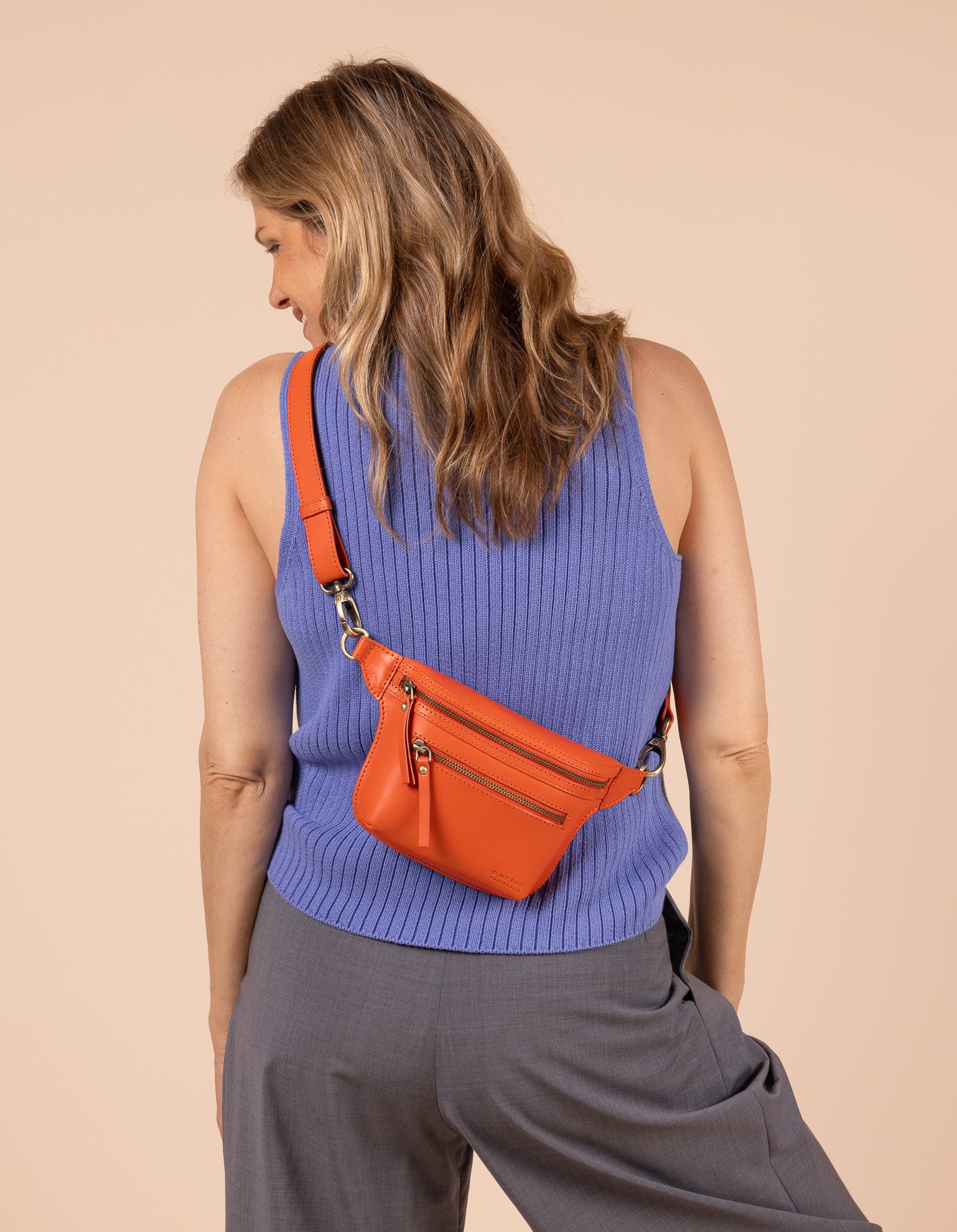 Model image showcasing Beck's Bum Bag tangerine classic leather fanny pack with adjustable leather strap