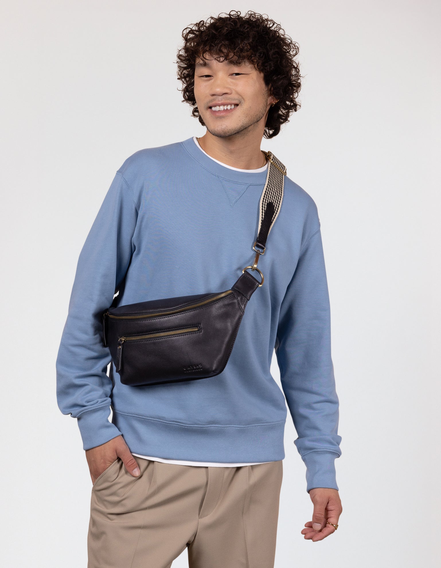 Model image of Drew Bum Bag black soft grain leather fanny pack with adjustable checkered webbing strap