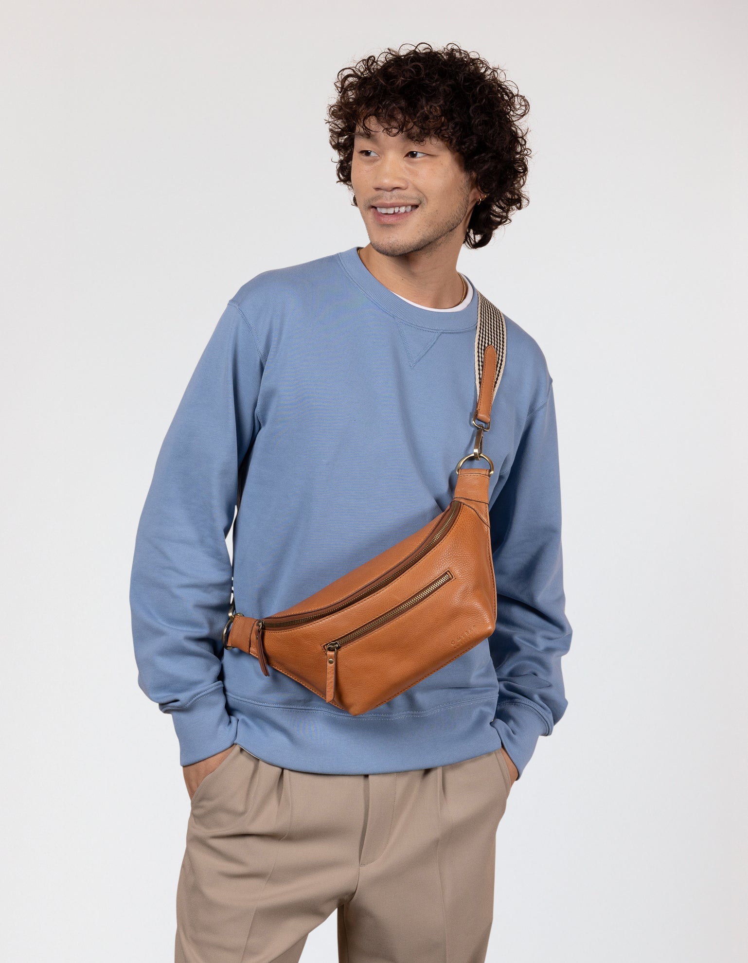 Male model with brown bumbag and blue jumper