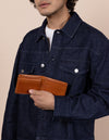 Joshua cognac leather wallet. Male model image.