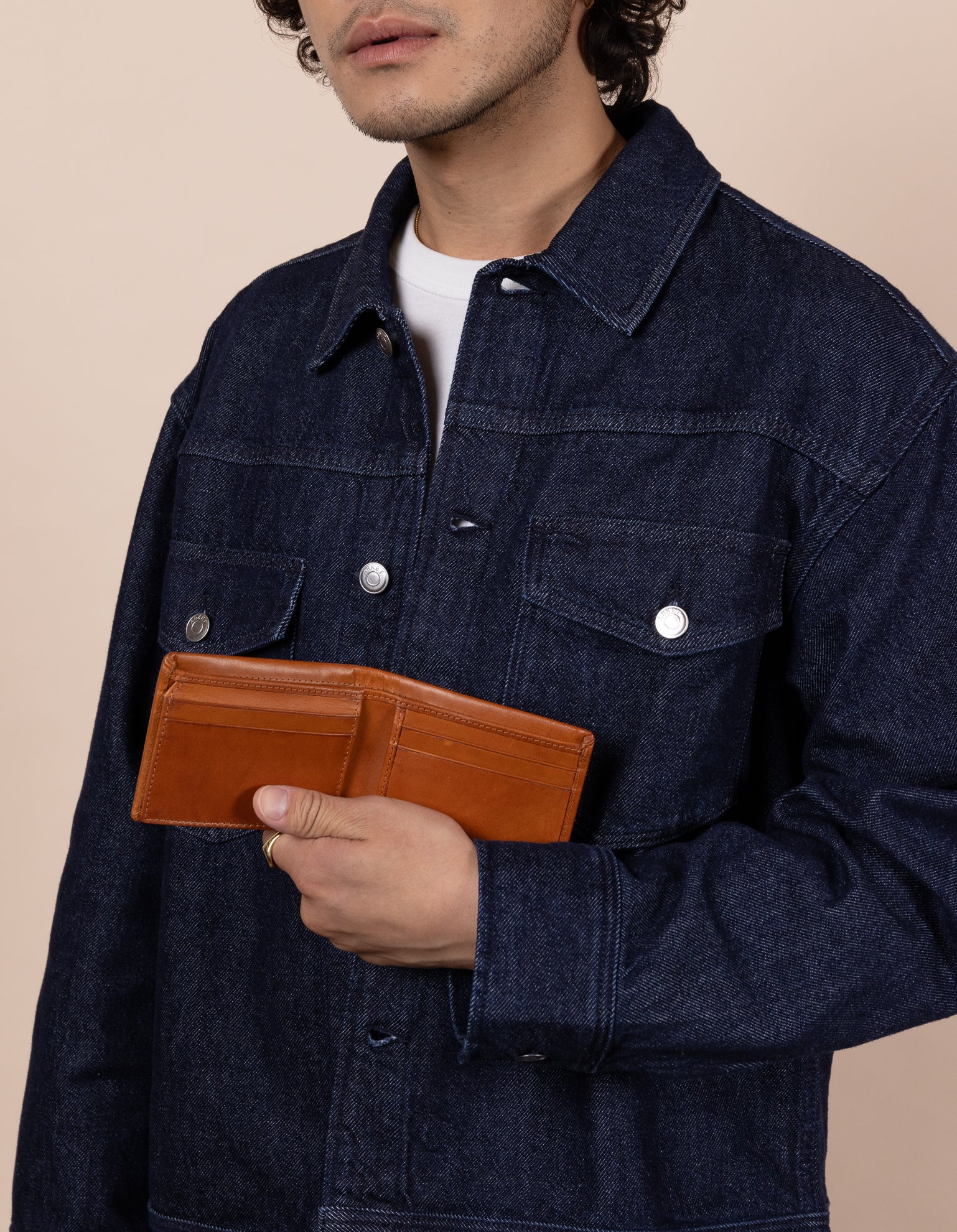 Joshua cognac leather wallet. Male model image.