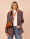 Model image showcasing Maya cognac classic leather crossbody bag with adjustable leather strap