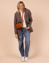 Model image showcasing Maya cognac classic leather crossbody bag with adjustable leather strap