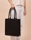 Mila Long Handle Black Classic Leather. Large rectangular shopper for women. Model image.