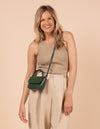 Model image showcasing Audrey Mini pine green classic leather crossbody bag with adjustable leather strap