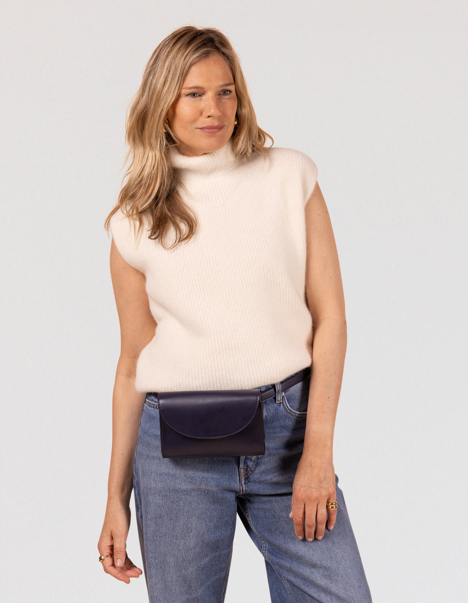 Ecom model image of blond woman model wearing a small navy belt bag