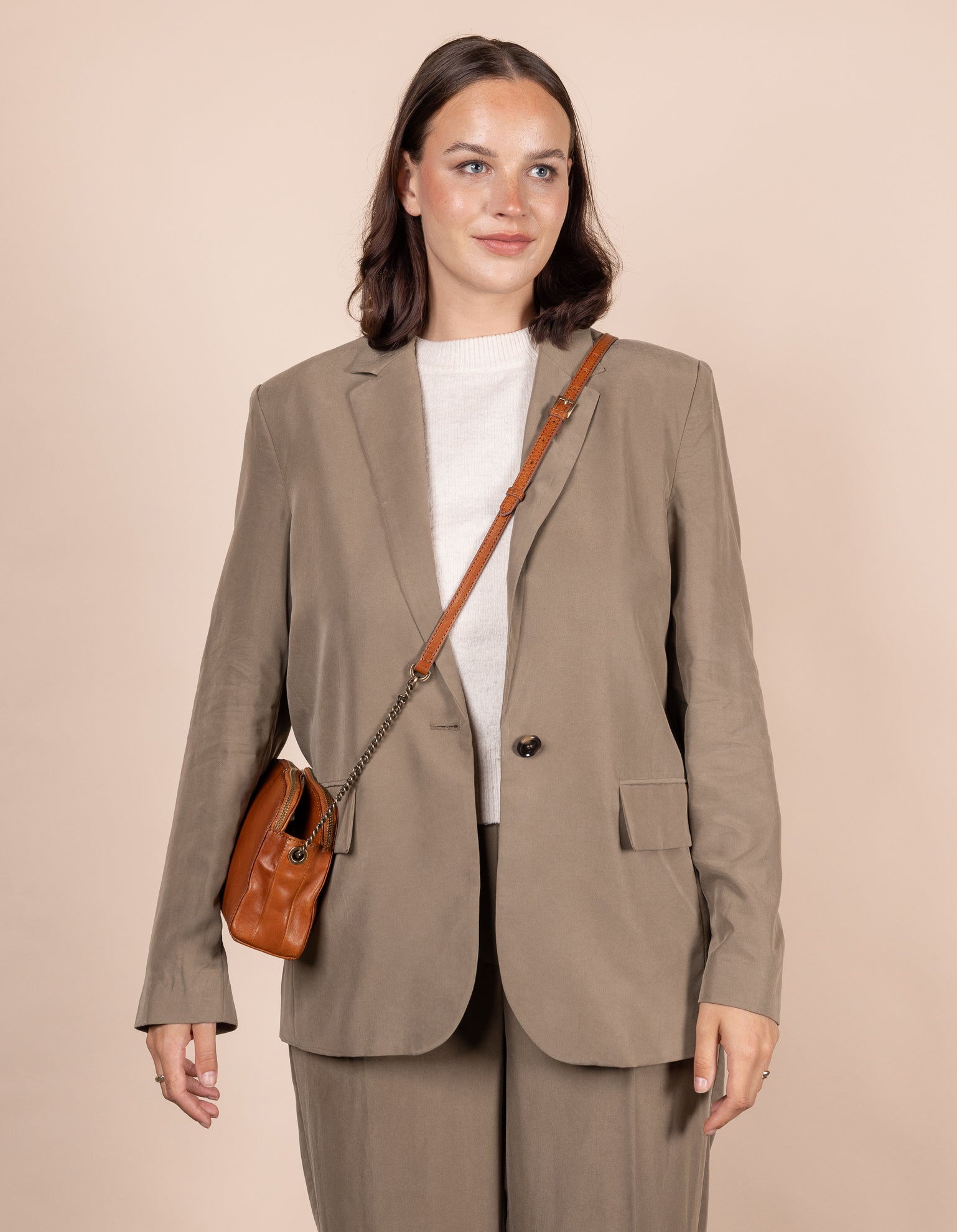 Cognac Leather womens handbag. Square shape with an adjustable leather & chain strap. Model image.