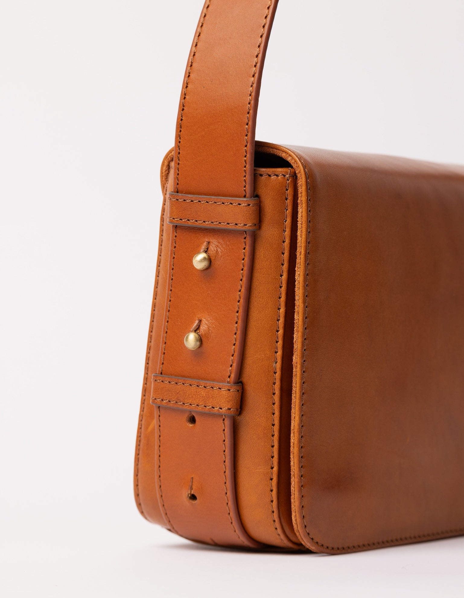 Cognac Baguette Leather womens handbag. Square shape with an adjustable strap. Close-up of adjustable strap details.