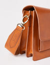 Harper Cognac Classic Leather. Accordion style midi crossbody bag. Product details close-up of hardware, dog hook, strap, and bag.