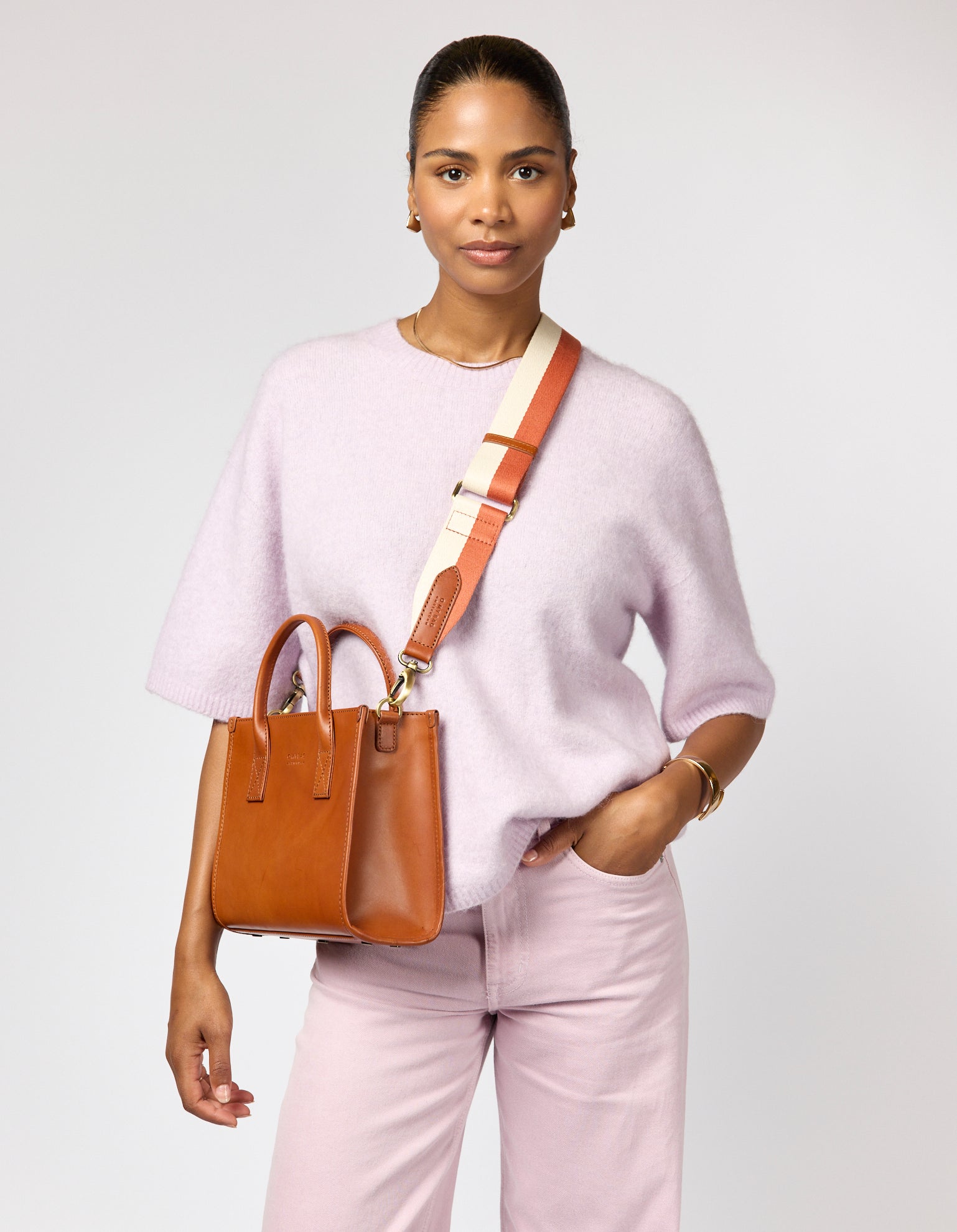 Female model wearing pink outfit with brown leather tote bag and cotton strap