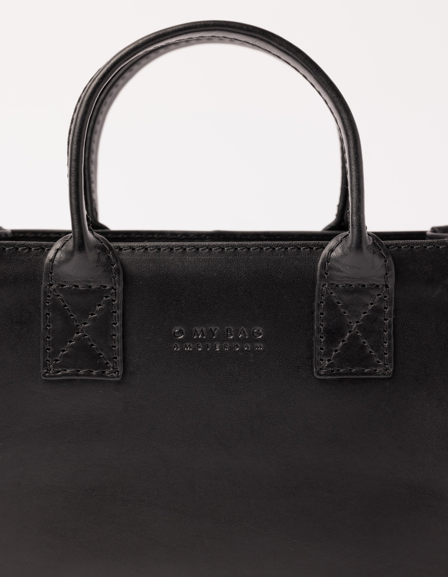 Rectangle shaped mini leather bag - close-up of handle and logo details.