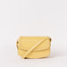 Front view of Kendalini in Butter Yellow-coloured leather with strap
