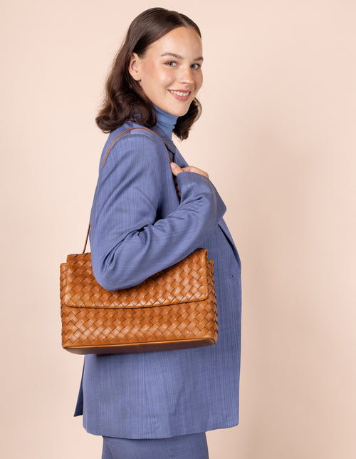 Female model with cognac woven Kenzie bag on shoulder