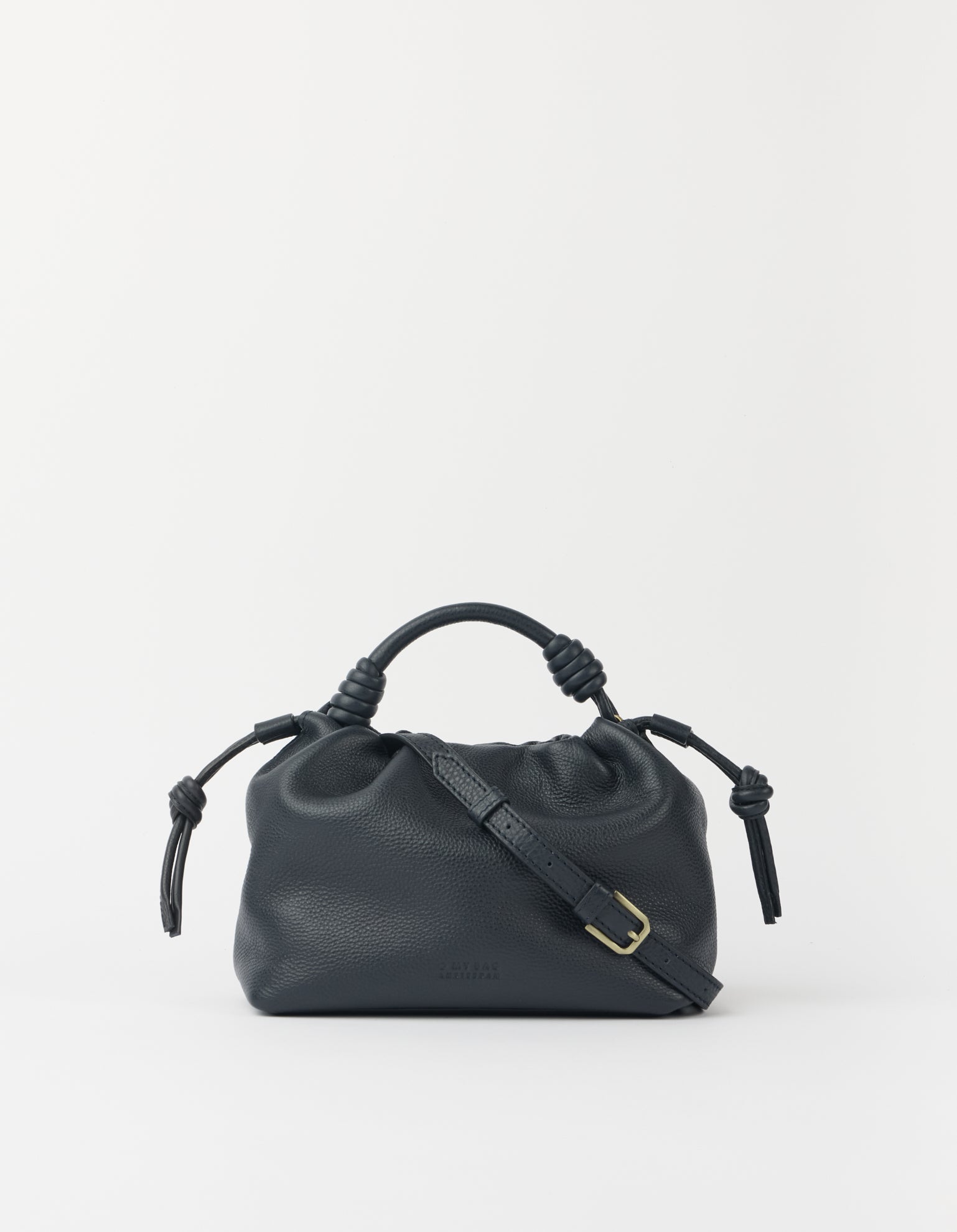 Blue leather handbag with knotted handle on a light gray background