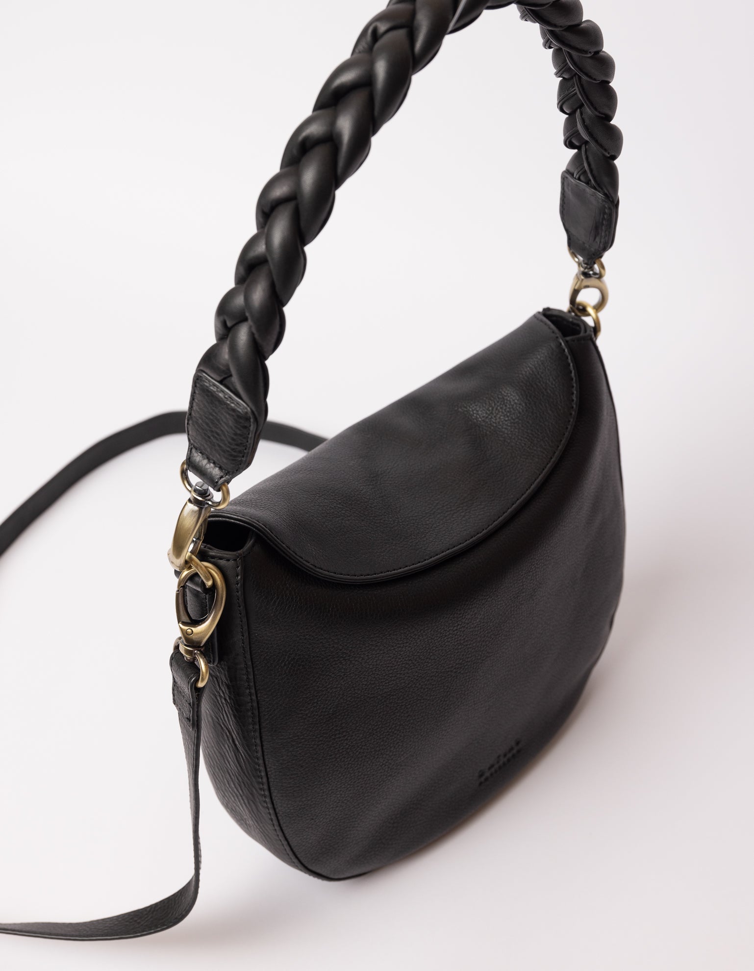 black bag on white background - photo of a strong braided and classic leather strap hooked on the bag