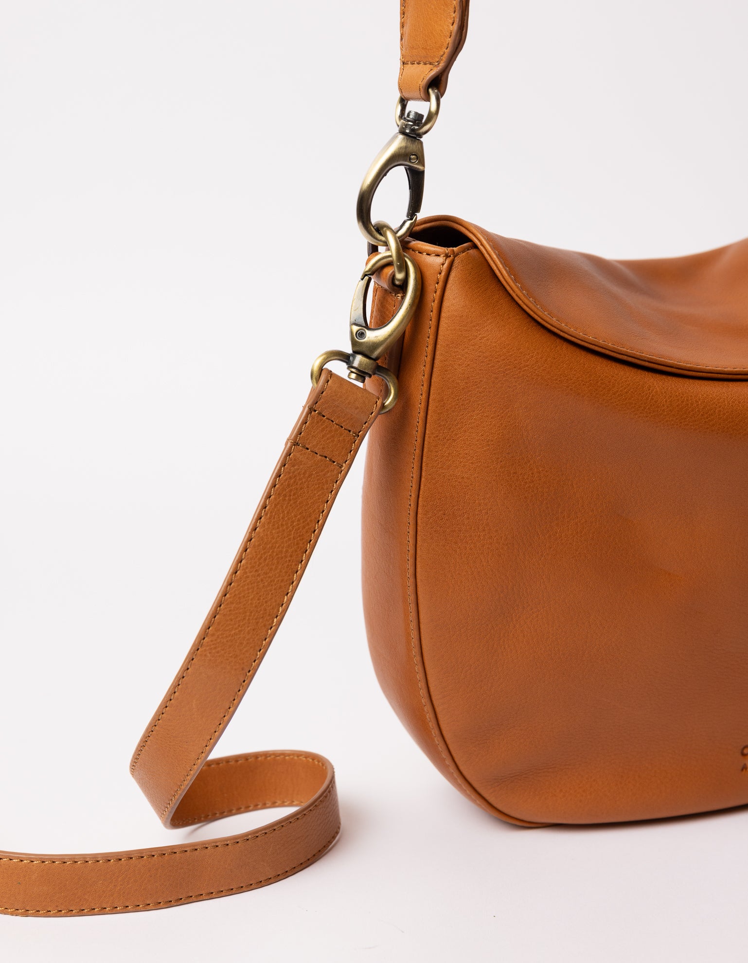 cognac bag on white background - close up of 2 strap carabiners hooked on the bag