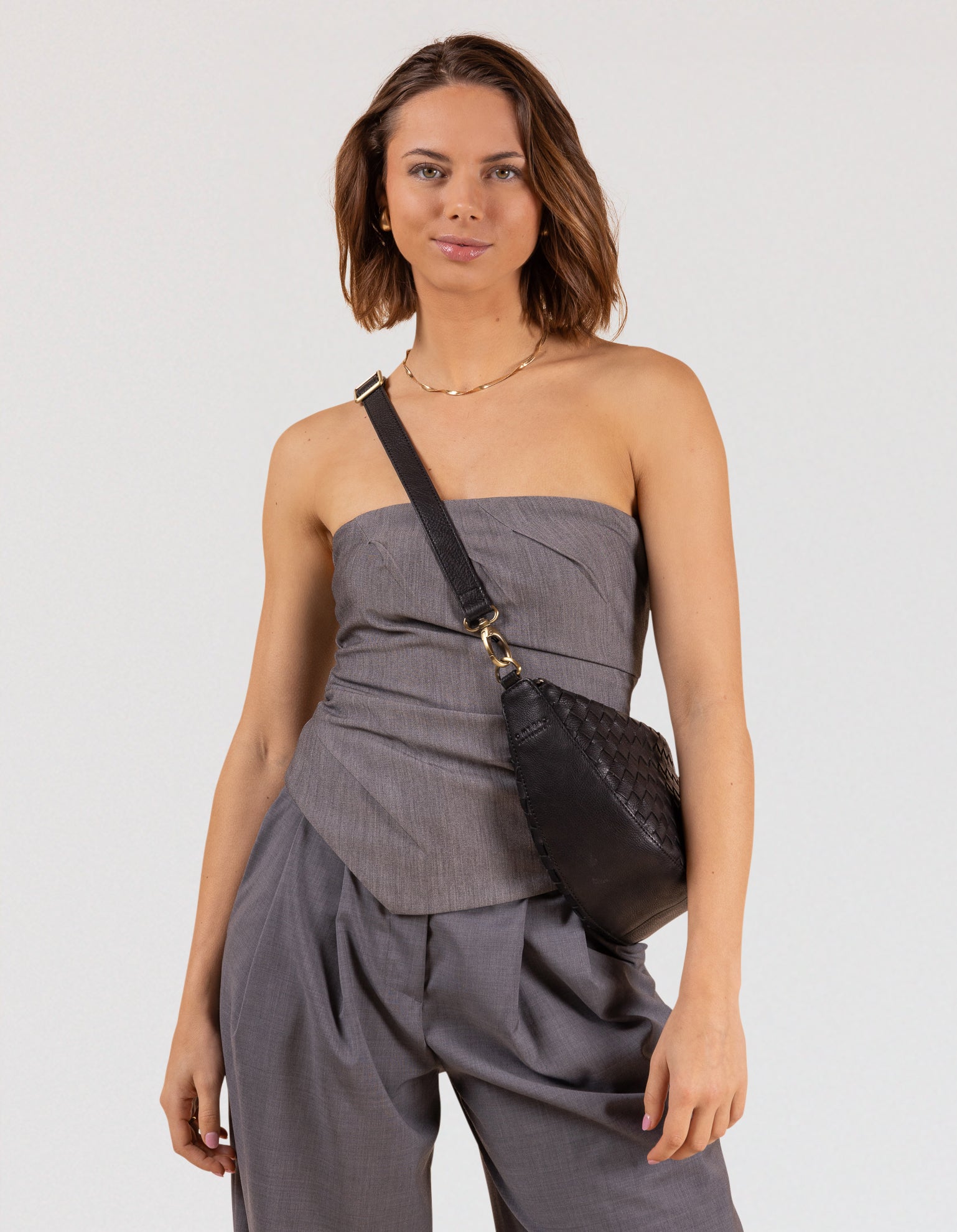 Model wearing "Leo" bag in woven black leather