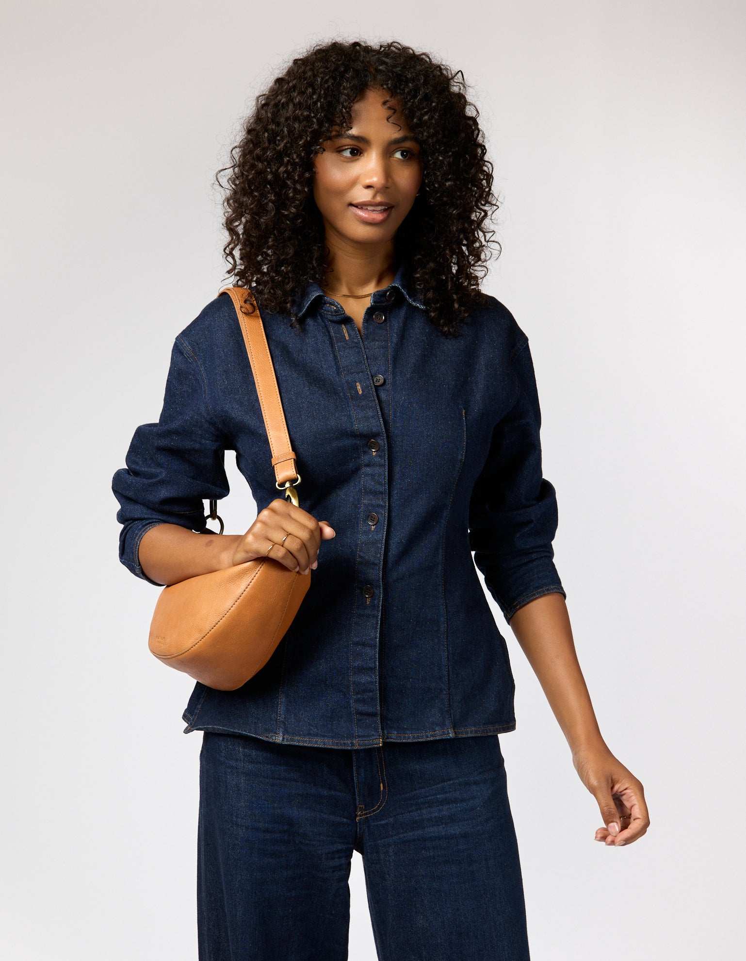 female model with denim outfit and brown leather bag with leather strap