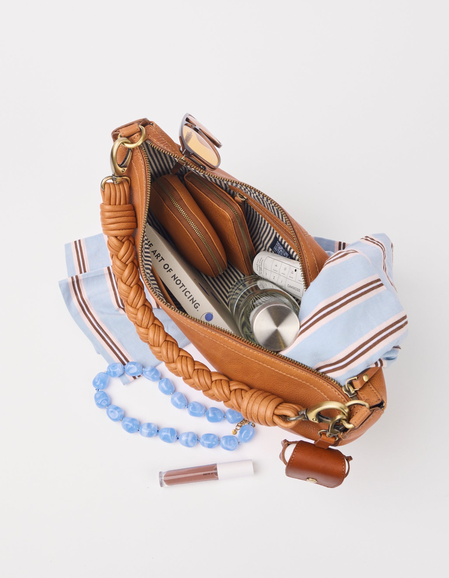 brown leather bag with objects inside