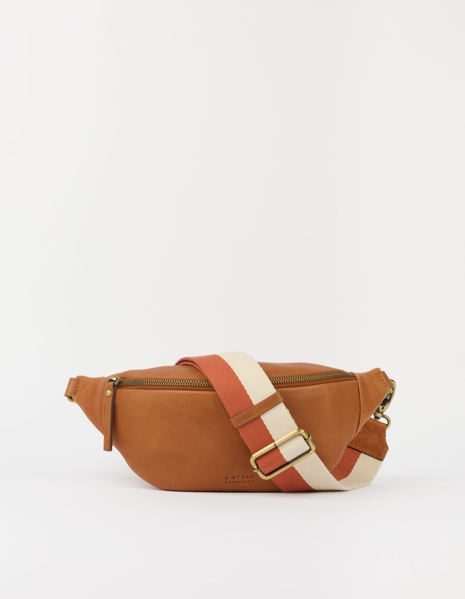 A tan leather fanny pack with a wide, adjustable woven strap in terracotta red and cream, featuring a gold-tone buckle.