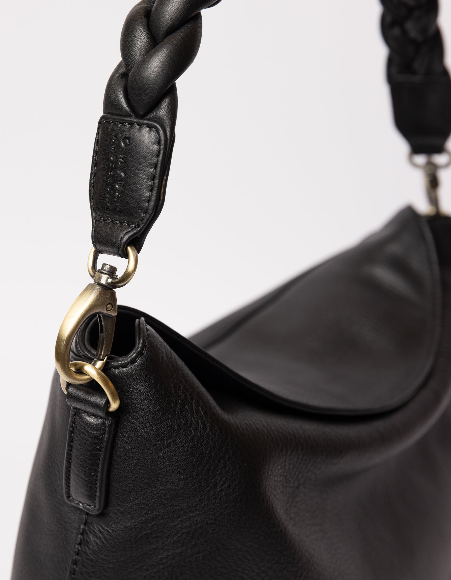 close up of hanging black bag hooked on the black braided strap