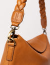 cognac bag on white background - close up of hanging bag hooked on strap carabiner