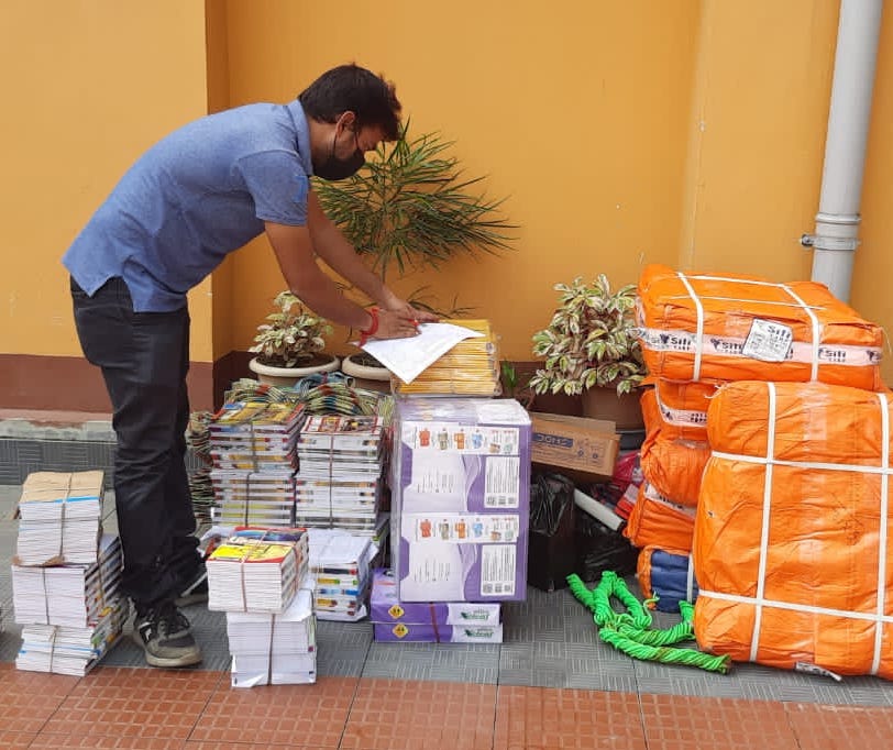 man bringing school supplies to kids in India