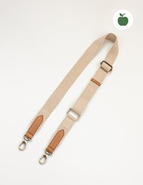 Herringbone webbing strap in sand with Cognac Apple Leather details. Front product image.