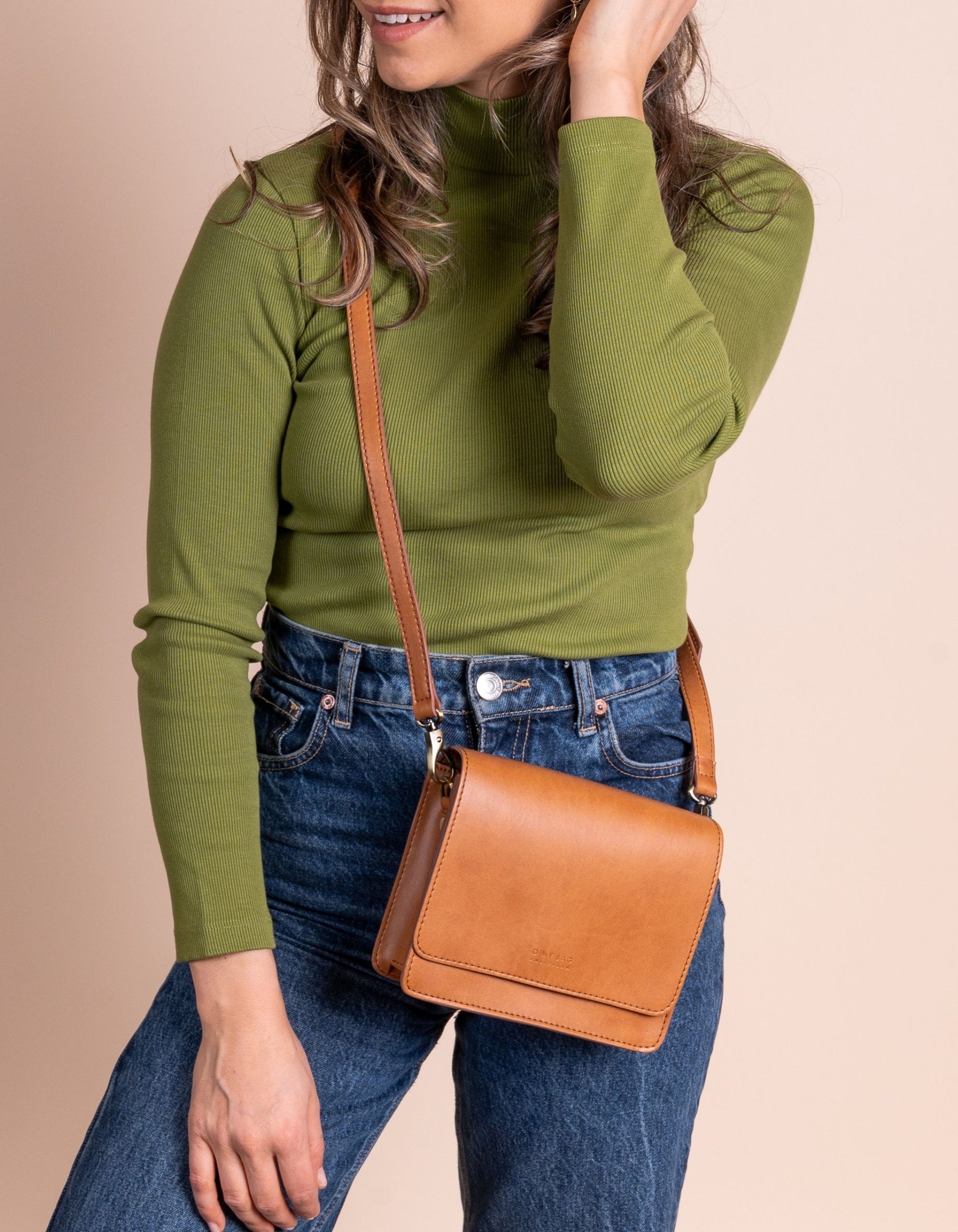 Model wearing brown crossbody bag with brown strap
