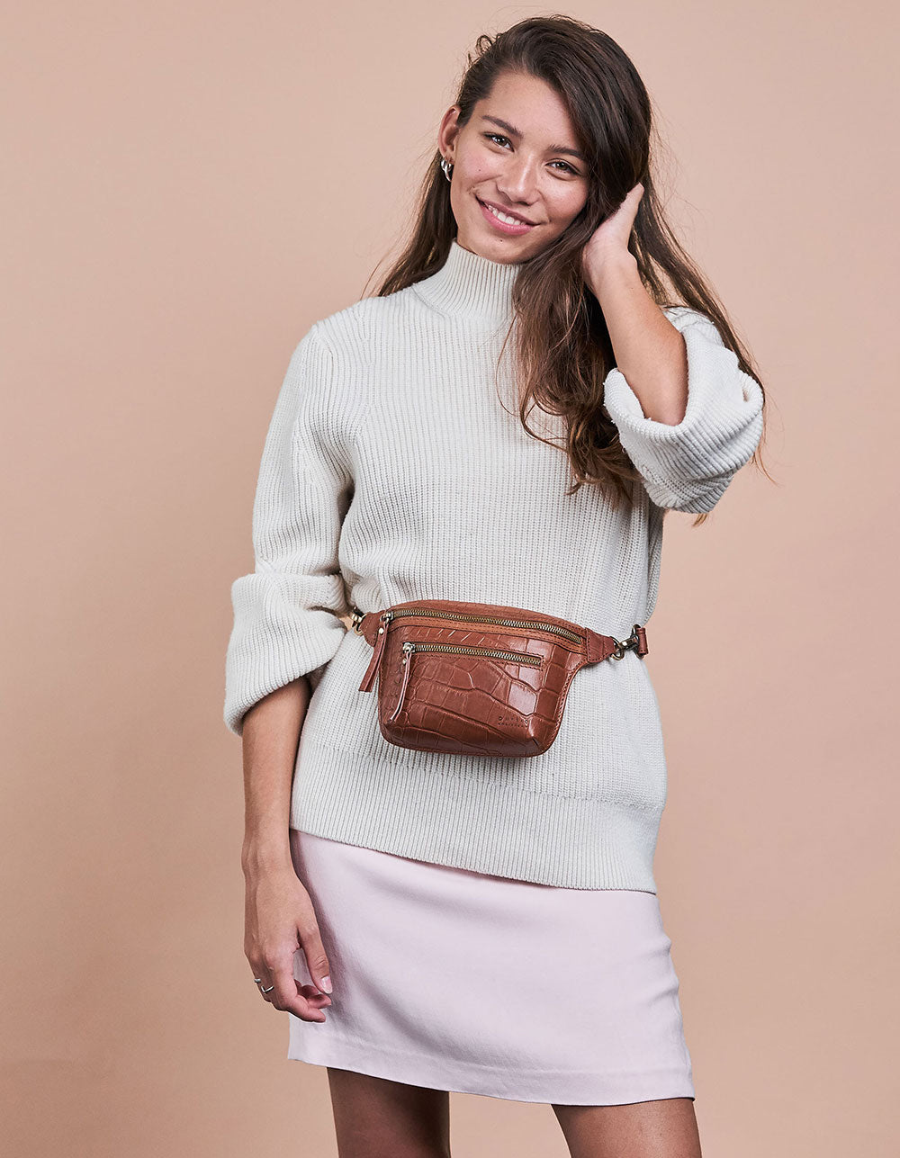 Cognac Croco Leather fanny pack. Square shape with an adjustable strap. Model product image