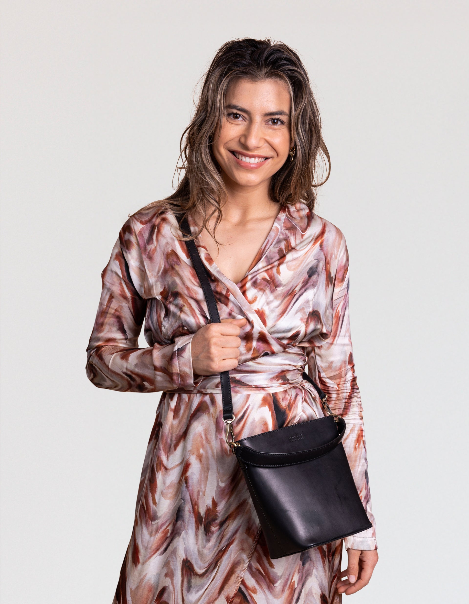 Female model with black leather bucket bag