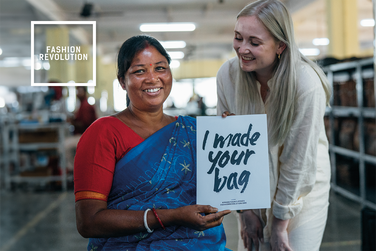 Image of indian women holding a sign and blond women with her.