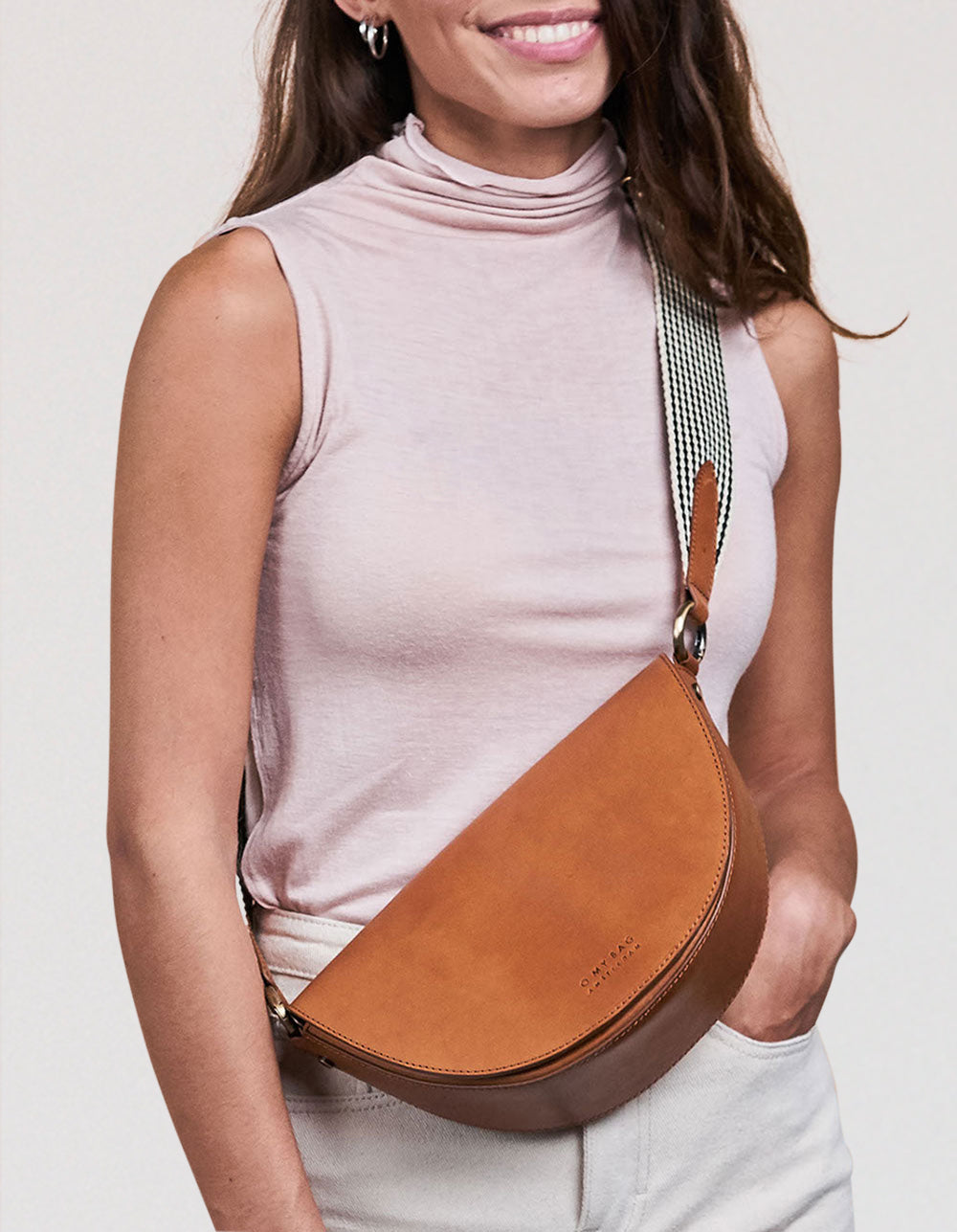 Female model with brown saddle bag made of leather